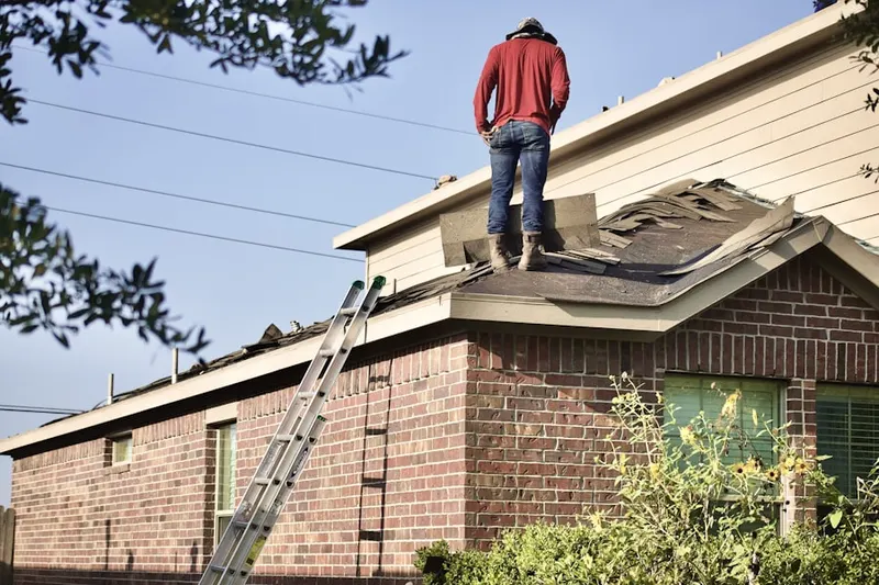 Professional roofer working on a residential roof in Greenville Manor